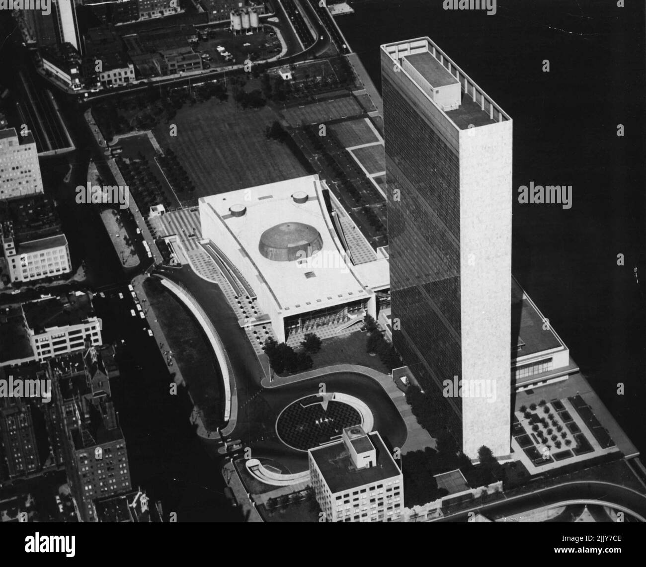 Vue aérienne du Siège de l'Organisation des Nations Unies -- Photographie noir et blanc d'une photographie aérienne en couleur du Siège de l'Organisation des Nations Unies, à New York. Cette photo, prise du Sud, montre tous les bâtiments de l'Union (dans le sens des aiguilles d'une montre de haut en bas : l'Assemblée générale, partie de la zone de la Conférence le long de la rivière, le Secrétariat et la Bibliothèque) avec, à gauche, la place des Nations Unies et, à droite, la rivière est. 1 janvier 1954. (Photo des Nations Unies). Banque D'Images