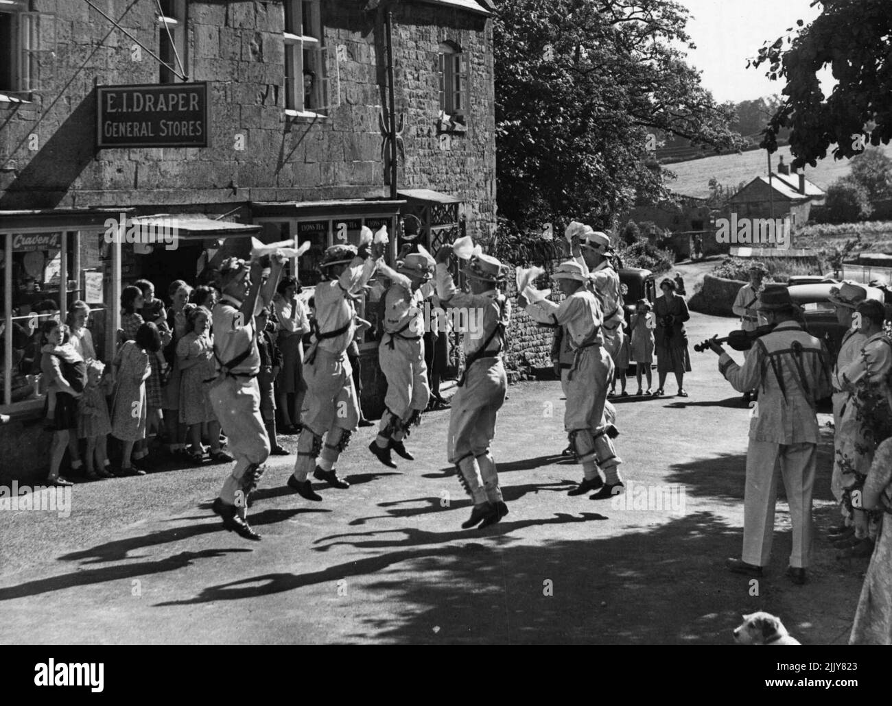The Morris Dancers of Bourton-on-the-Hill - cette équipe de Morris Dancers fait une visite du village de Cotswold chaque année. Ils sont vus danser par le magasin du village à Bourton sur la colline. Certains des plus grands villages ont leurs propres équipes de danseurs qui se joignent fréquemment aux visiteurs. 5 septembre 1950. (Photo de Fox photos). Banque D'Images