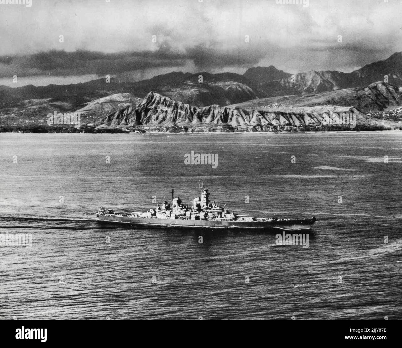 Le puissant USS Missouri Sails pour les États-Unis -- le puissant USS Missouri, navire amiral de la troisième flotte, est effiloché contre la robustesse de Diamond Head, a fait le point de repère hawaïen, car il navigue pour le coût est des États-Unis à partir de Pearl Harbor septembre 29. Le Missouri, site de la signature de la capitulation du Japon, a été désigné comme le navire amiral de la flotte des États-Unis, la plus grande armada jamais à naviguer dans les mers. Le cuirassé jouera un rôle de chargement dans les cérémonies de la Journée de la Marine aux États-Unis. 25 octobre 1945. (Photo de la Marine américaine officielle) Banque D'Images