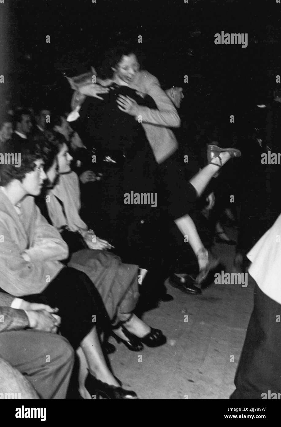 Leurs sièges à un concert de jazz dans l'Empress Hall de Londres et ont commencé à jiner devant le kiosque ont été poussés du concert. Six milliers de personnes dans l'auditoire ont vu deux filles exécutées par des commissaires. Les cris sont arrivés lorsque l'orchestre de concert de Vic Lewis a commencé à jouer « Concerto pour mettre fin à tous les concertos ». Plus tard, une douzaine de couples ont quitté l'arrière de la salle et ont commencé à jiner. Certains couraient vers l'avant. Les commissionnaires en ont fait quelques-uns. D'autres ont été glissés sur transporté. Un responsable a déclaré. « C'était grave. La danse n'est pas autorisée un dimanche. C'était juste un concert." 17 avril 1950. (Photo par Daily Mirror). Banque D'Images