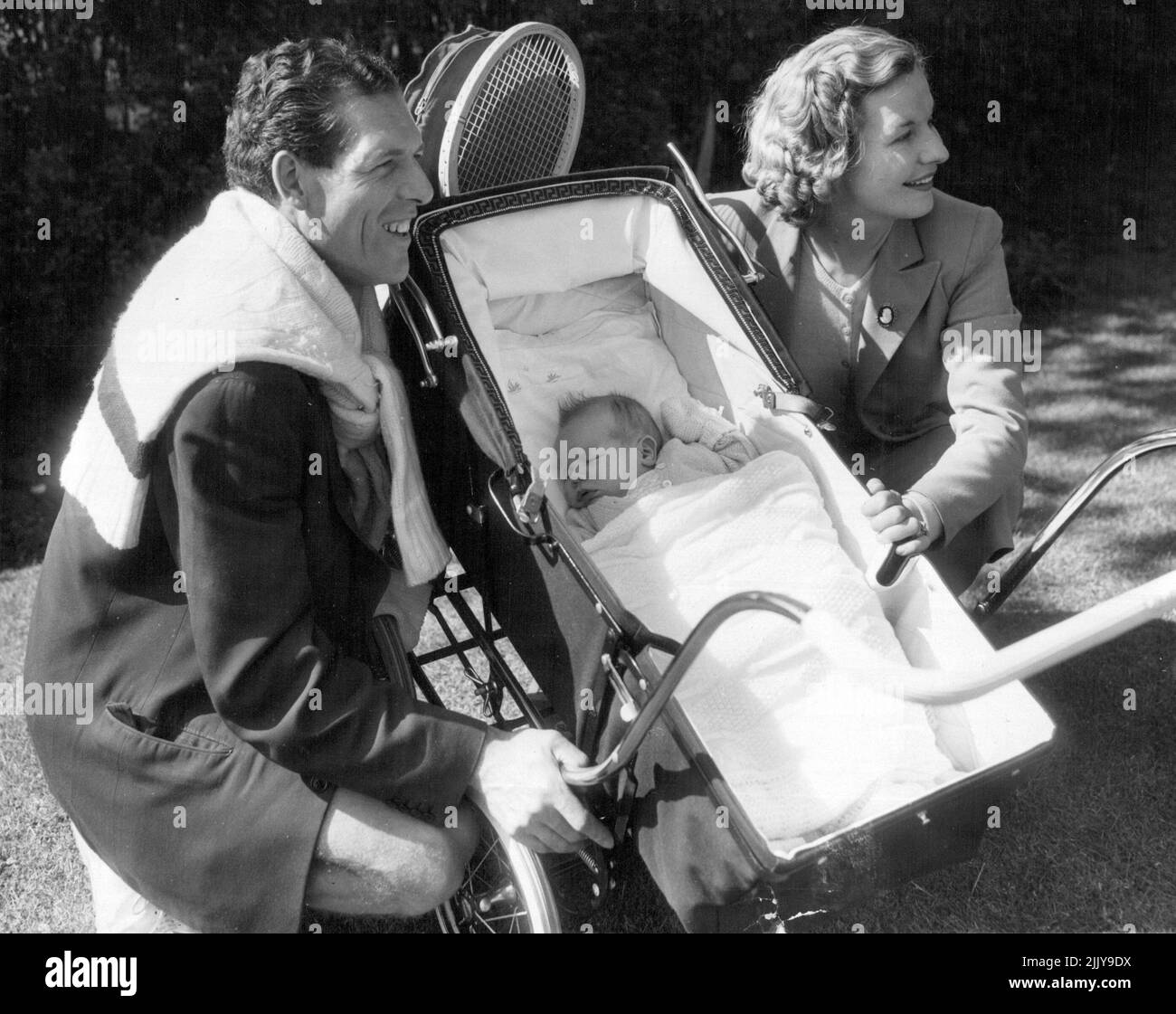 Tony Mottram et son épouse Joy (anciennement Miss Joy Gannon) sont les parents fiers du Northern Open Lawn tennis Tournament à Manchester qui ont permis aux admirateurs de faire un petit peep à leur fils de 5 semaines Christopher John, qui a dormi à travers tout. 31 mai 1955. Banque D'Images