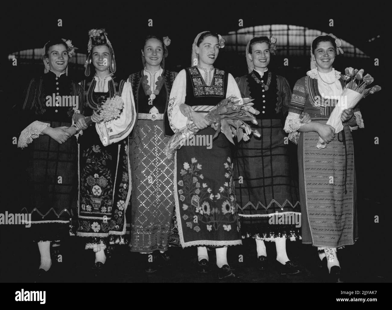 Coloré comme le printemps de Londres prend un look plus lumineux avec ces costumes de Bulgar à multiples motifs, portés par les membres de la compagnie de musique et de danse d'État bulgare arrivant à la gare Victoria à jour (Vendredi Saint) de Paris pour ouvrir une saison de trois semaines au Winter Garden Theatre. L'entreprise, forte en 110, effectue une tournée de bonne volonté des capitales européennes. En 1953, elle a été lauréate du Festival de la Jeunesse de Bucarest et a remporté le même honneur l'année dernière au Festival du Printemps de Prague. 8 avril 1955. (Photo de Reuterphoto). Banque D'Images