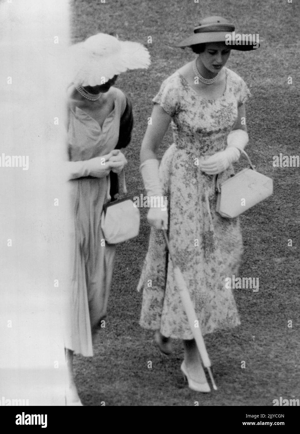 La princesse Alexandra porte une grenouille fleurie et porte un sac à main blanc et un parapluie soigneusement roulé assorti dans un jardin ***** donné par la ***** À Buckingham ***** Palais. 22 juillet 1954. Banque D'Images