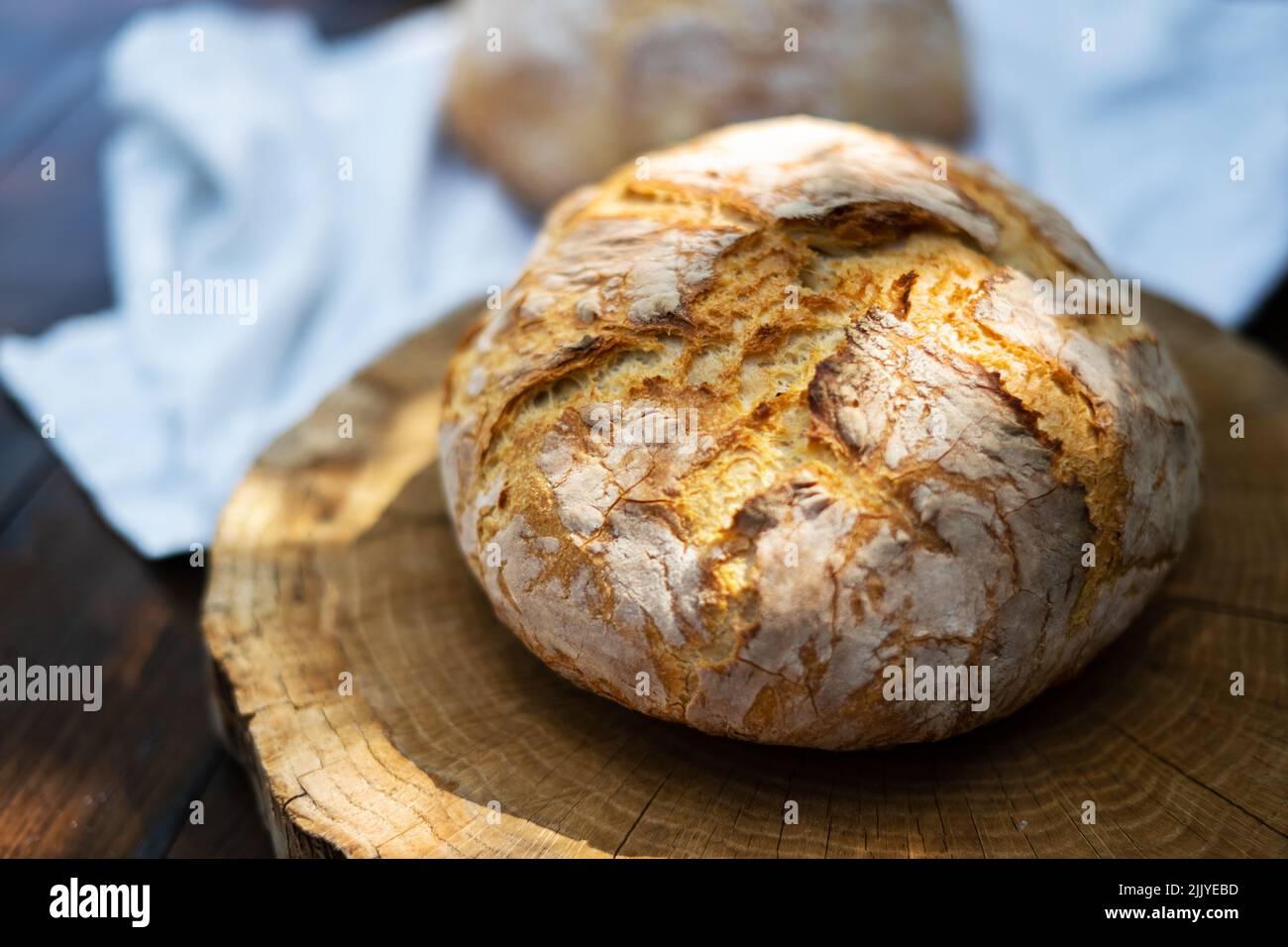 Pain traditionnel levain levain levain à la peau lisse sur une table rustique en bois. Photographie d'aliments sains Banque D'Images