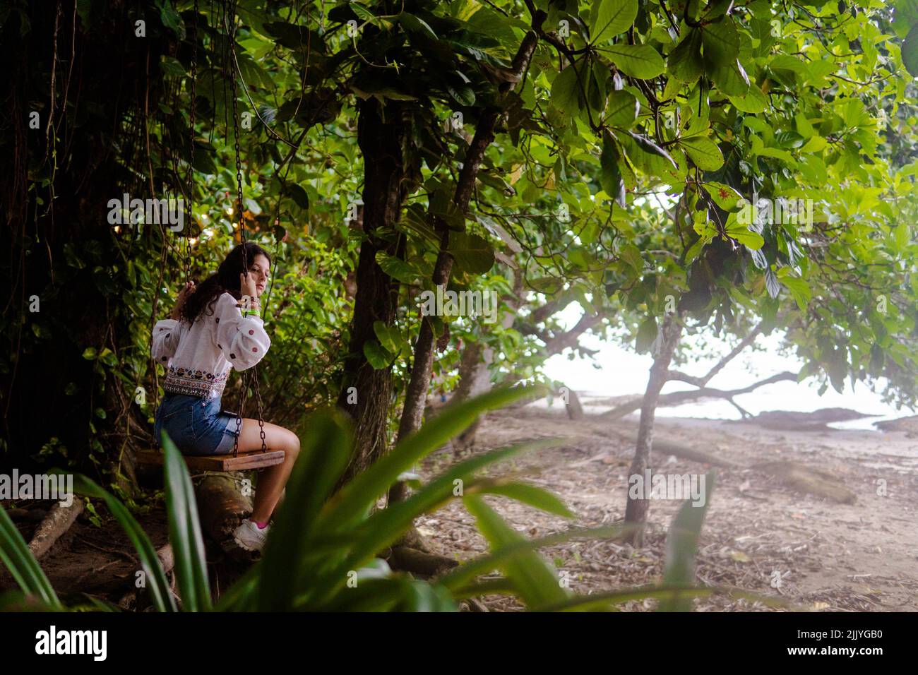 Femme assise sur une balançoire dans la jungle du Costa Rica Banque D'Images
