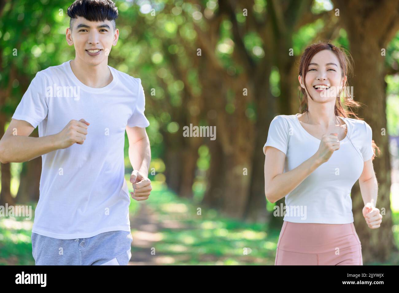 un jeune couple fait du jogging ensemble dans le parc par beau temps Banque D'Images