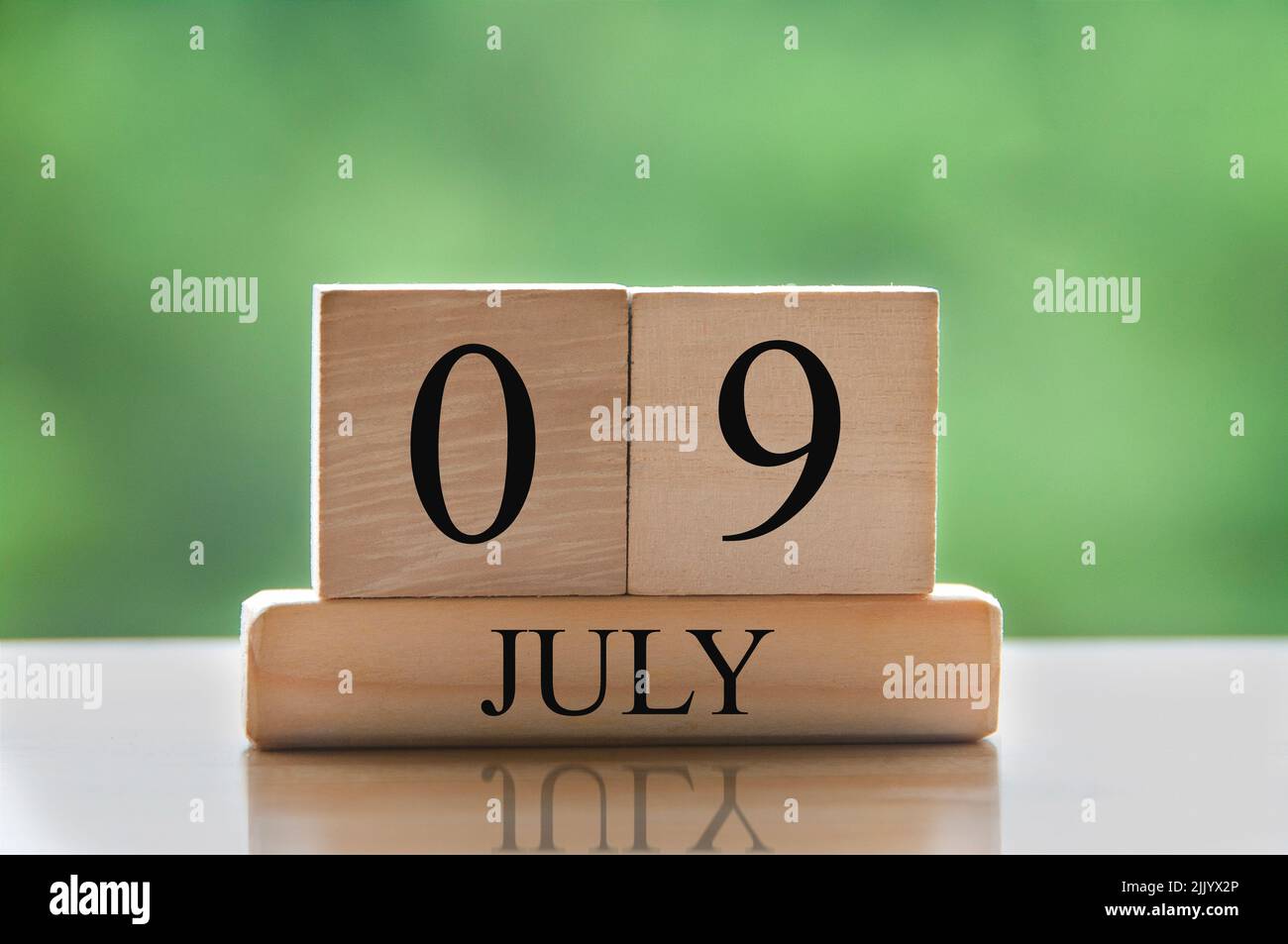 Texte de date du calendrier 9 juillet sur des blocs de bois avec parc d'arrière-plan flou. Concept de calendrier Banque D'Images