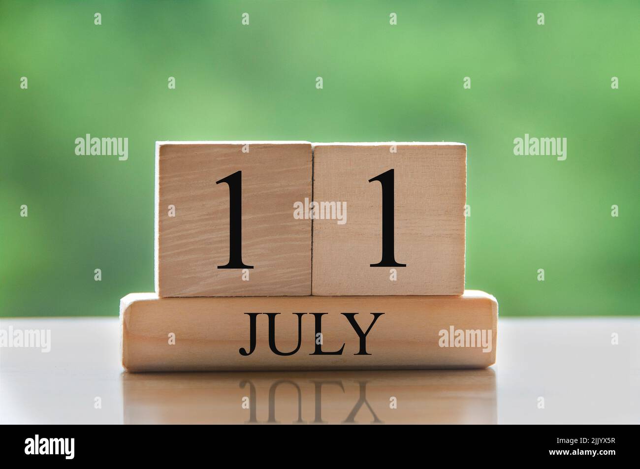 Texte de date du calendrier 11 juillet sur des blocs de bois avec parc d'arrière-plan flou. Concept de calendrier Photo Stock - Alamy
