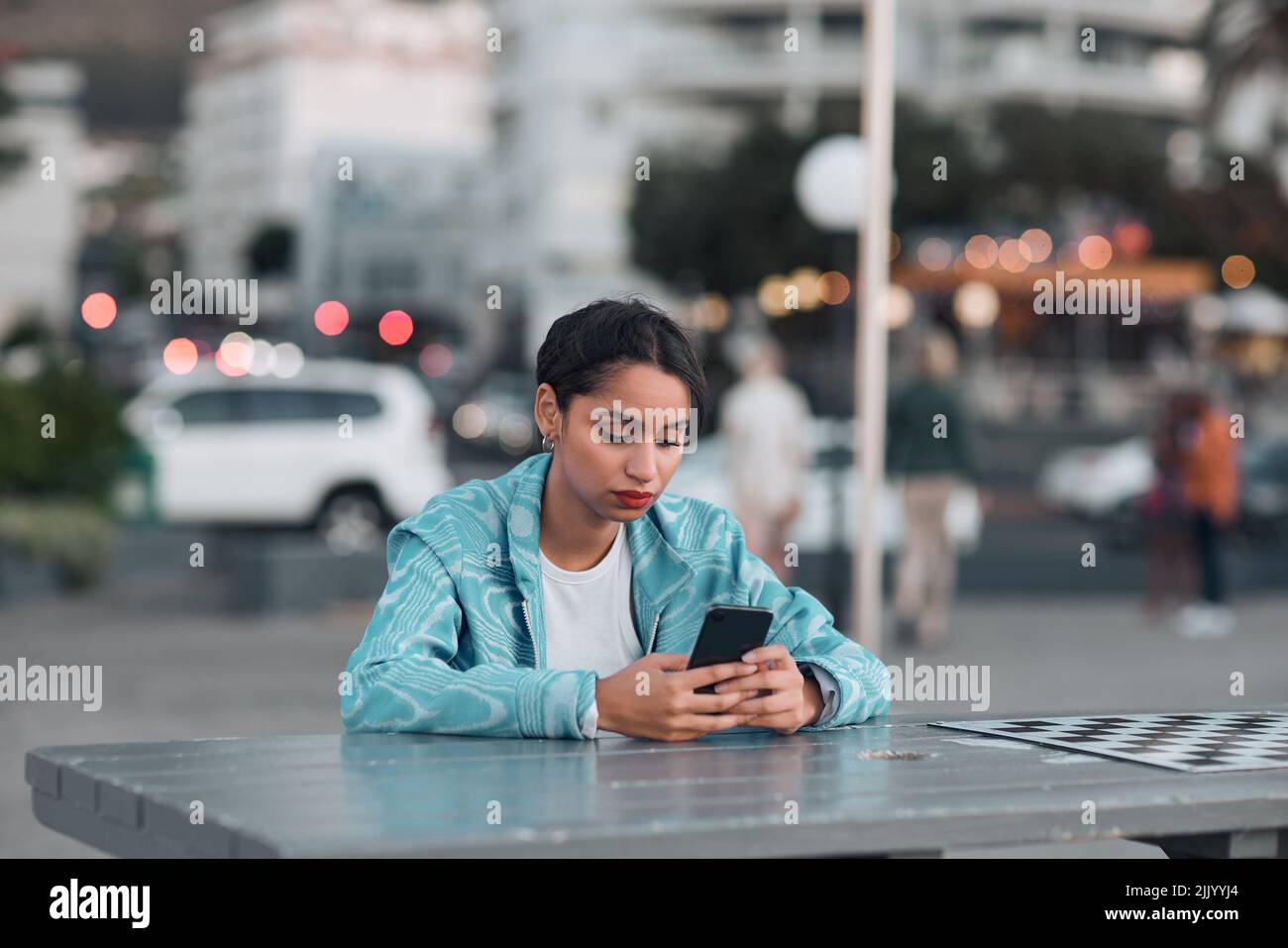 Femme dépressive, triste et ennuyeuse avec téléphone en attente et lecture de textes après avoir été debout sur le coucher du soleil ville date. Agacé, anti social et étudiant solitaire Banque D'Images