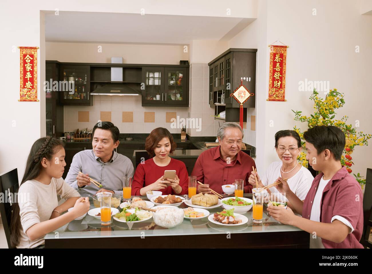 Grande famille asiatique appréciant un grand dîner pour la fête du nouvel an. Défile en souhaitant la chance et la richesse en arrière-plan Banque D'Images