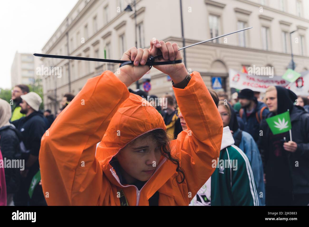 05.28.2022 Varsovie, Pologne. Prot-cannabis protster dans une veste orange imperméable portant une cravate sur les poignets pour symboliser la loi déloyale. Photo de haute qualité Banque D'Images