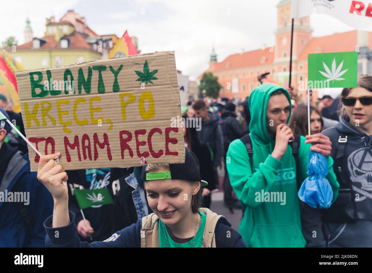 05.28.2022 Varsovie, Pologne. Jeu de mots amusant d'un jeune manifestant caucasien qui a créé un carton avec des lettres vertes, jaunes et rouges. Drapeau avec feuille de cannabis. Photo de haute qualité Banque D'Images