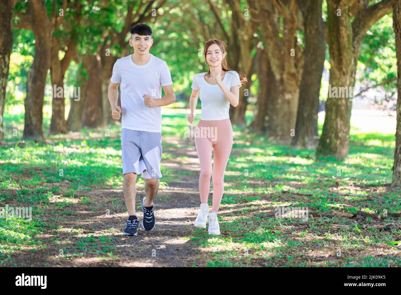 un jeune couple fait du jogging ensemble dans le parc par beau temps Banque D'Images