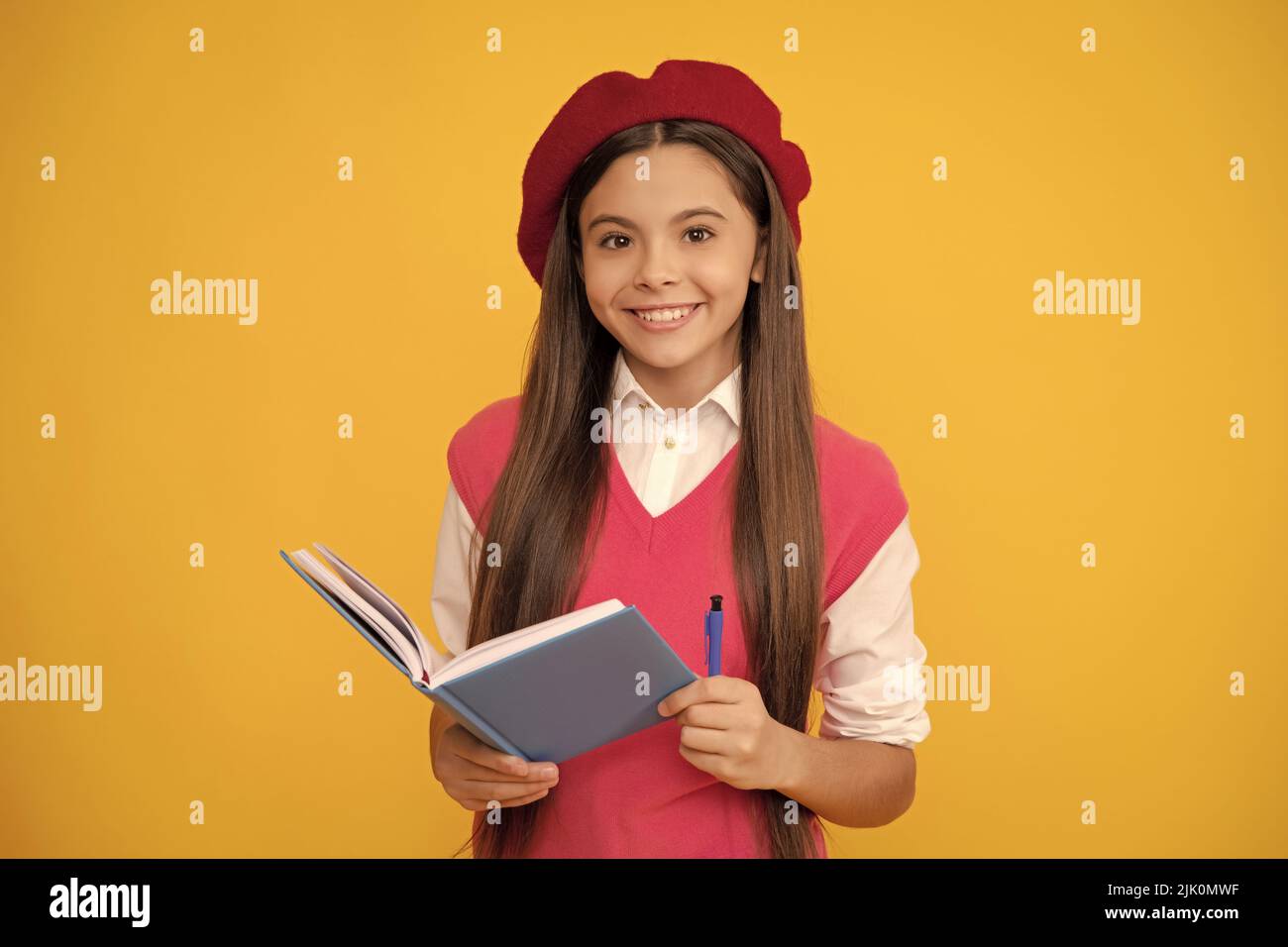bonne adolescente en béret français, en train de faire des notes dans le bloc-notes ou le bloc-notes de l'agenda, l'école Banque D'Images