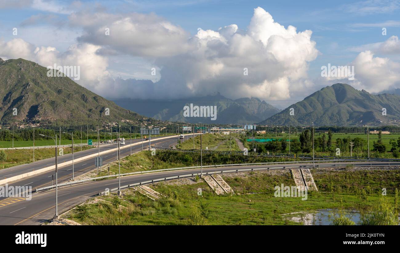La route tourne à droite de l'autoroute principale dans un village au Pakistan Banque D'Images