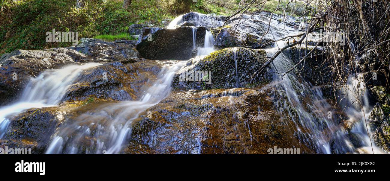 Vue panoramique d'une cascade d'eau tombant sur les rochers de la forêt enchantée. Madrid Guadarrama. Banque D'Images