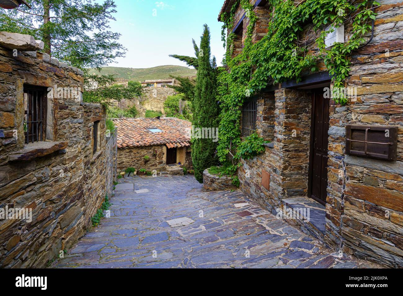 Rue étroite de la ville avec maisons anciennes et vue sur la montagne. Patones de Arriba Madrid. Espagne. Banque D'Images