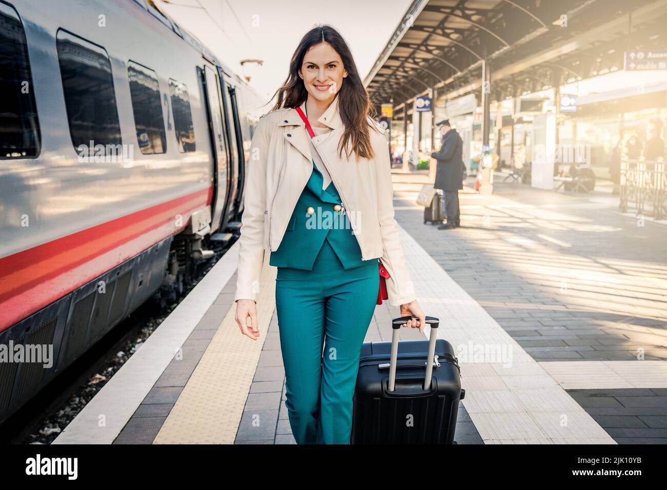 Portrait d'une femme d'affaires se rendant à pied dans une gare ou un aéroport à la porte d'embarquement avec ses bagages à main Banque D'Images