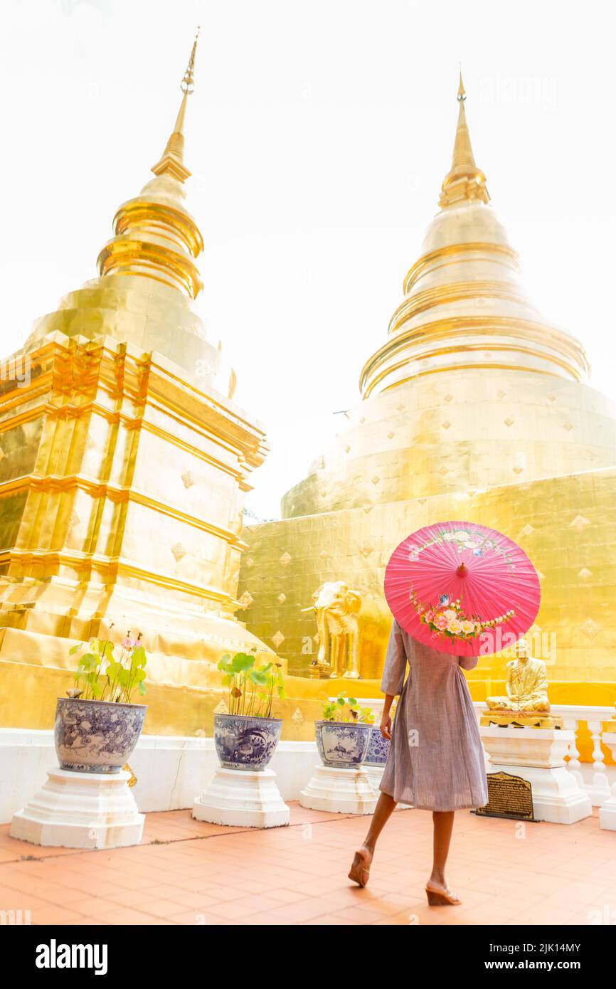 Femme avec parapluie rouge à Wat Phra Singh Woramahawihan, Chiang Mai, Thaïlande, Asie du Sud-est, Asie Banque D'Images Femme avec parapluie rouge à Wat Phra Singh Woramahawihan, Chiang Mai, Thaïlande, Asie du Sud-est, Asie Banque D'Images