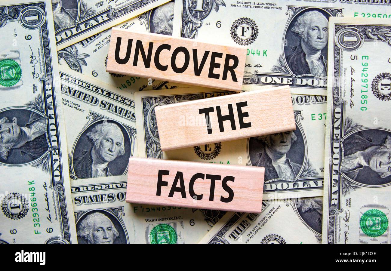 Découvrez le symbole des faits. Les mots de concept découvrent les faits sur des blocs de bois sur un beau fond de billets de dollar. Et découvrir les faits Banque D'Images