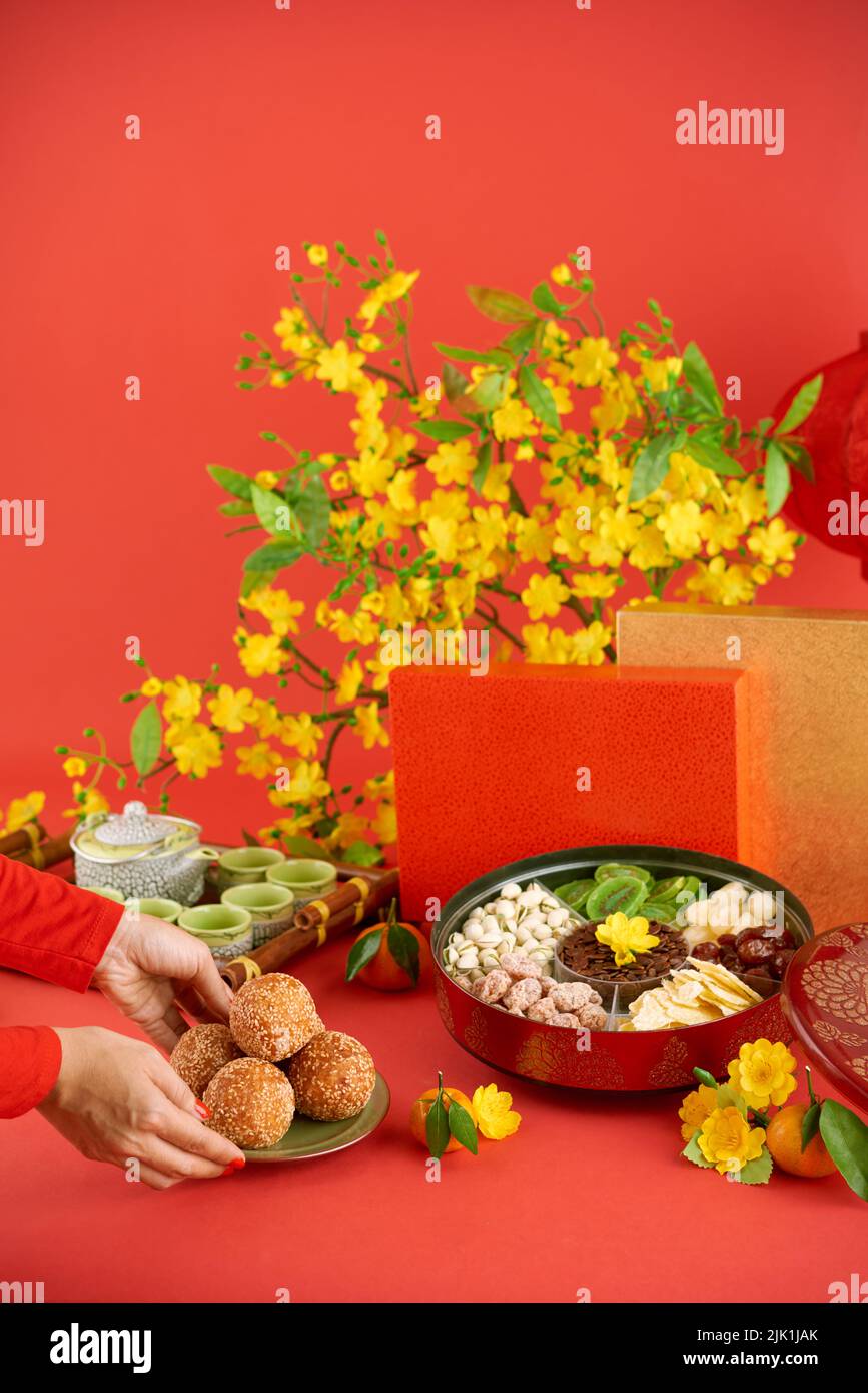 Mains de la femme apportant des boules de sésame frits à la table des fêtes Banque D'Images