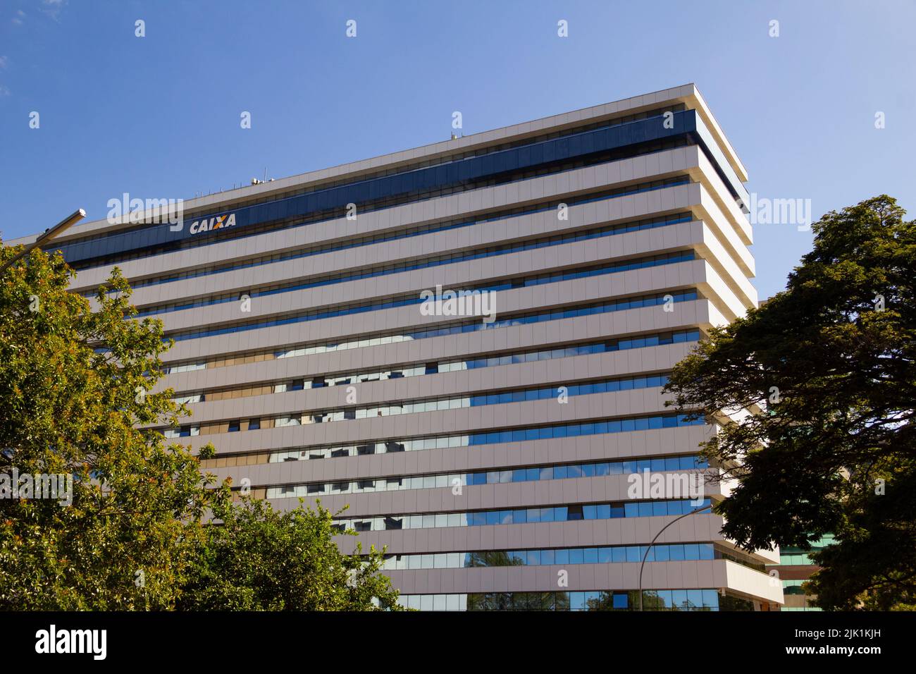 Brasília, District fédéral, Brésil – 23 juillet 2022: Façade de la Banque brésilienne Caixa Econômica Federal, entre les arbres, par temps clair avec le ciel bleu. Banque D'Images