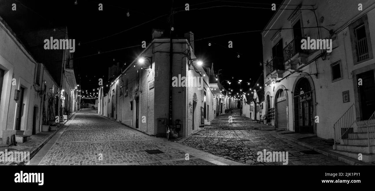 Pittoresque rue abandonnée dans le quartier Trulli d'Alberobello la nuit, sud de l'Italie Banque D'Images