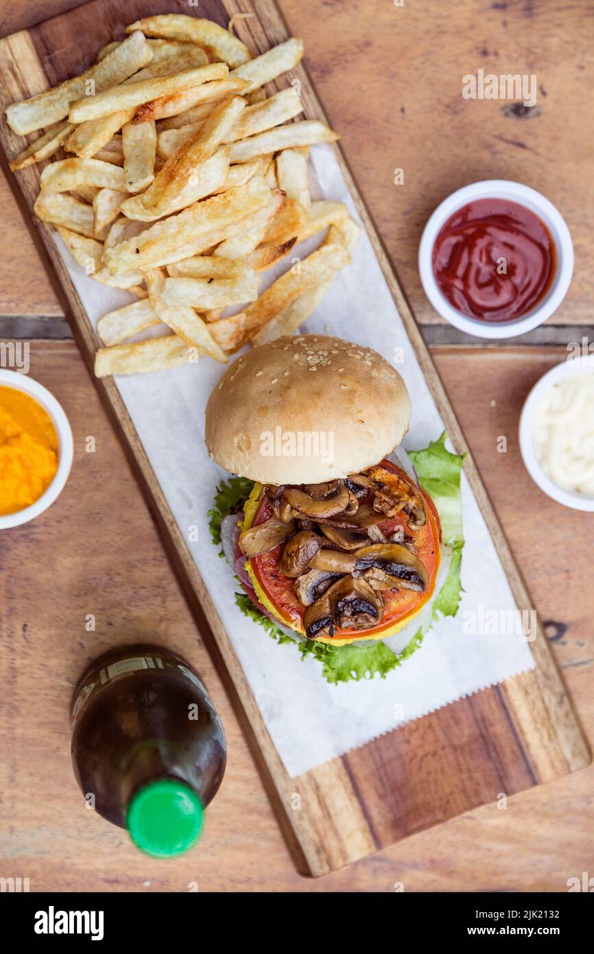 Cheeseburger aux légumes avec champignons, laitue, tomate, cheddar et œuf, frites Banque D'Images