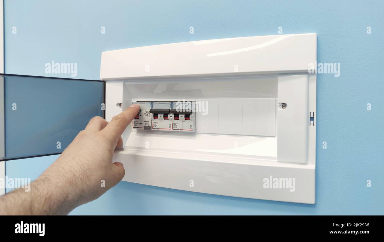 La carte de disjoncteurs affiche de nombreux interrupteurs. Un doigt est sur le point du réactiver. Banque D'Images