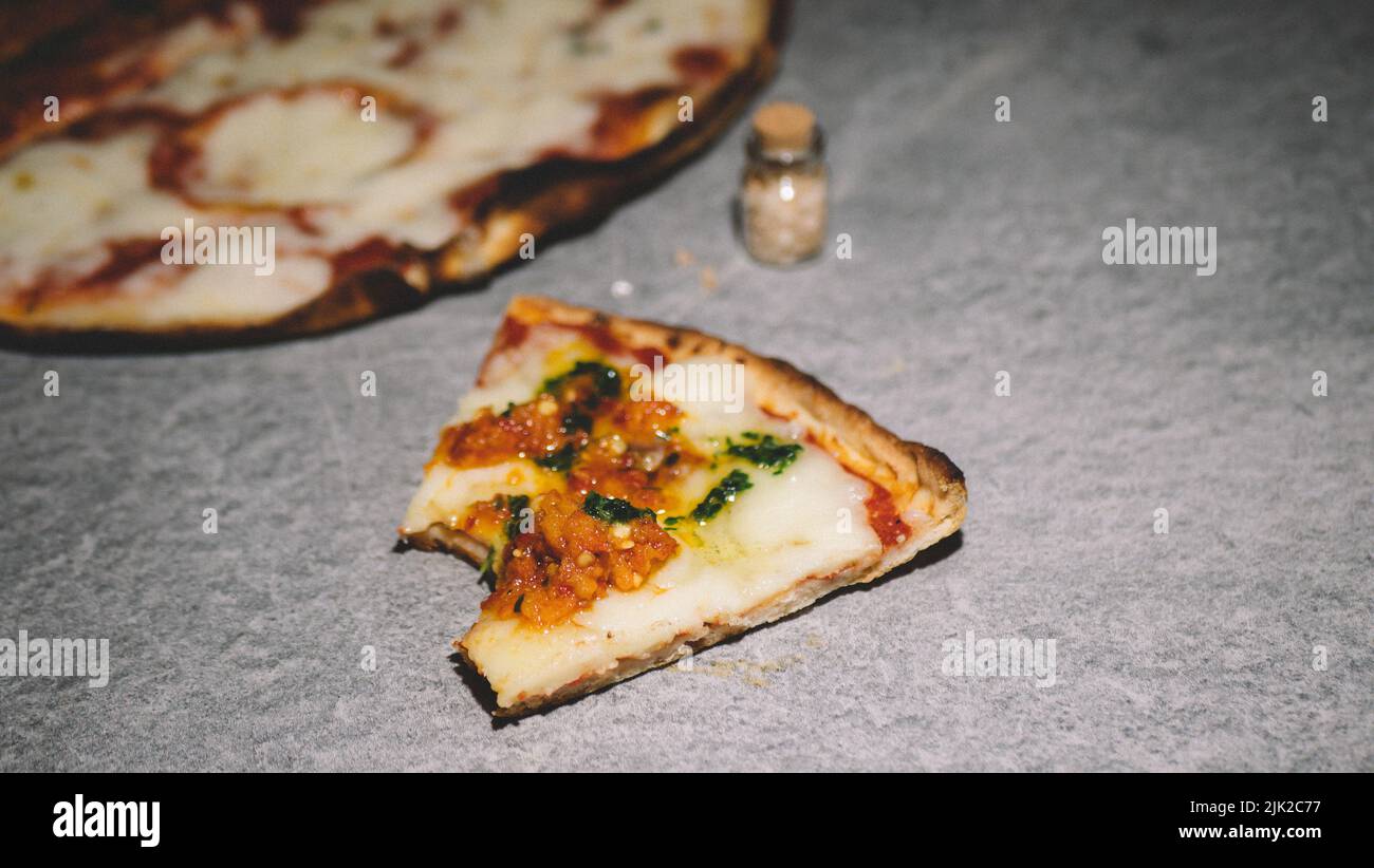 Piquer une tranche de pizza épicée sur un fond gris Banque D'Images
