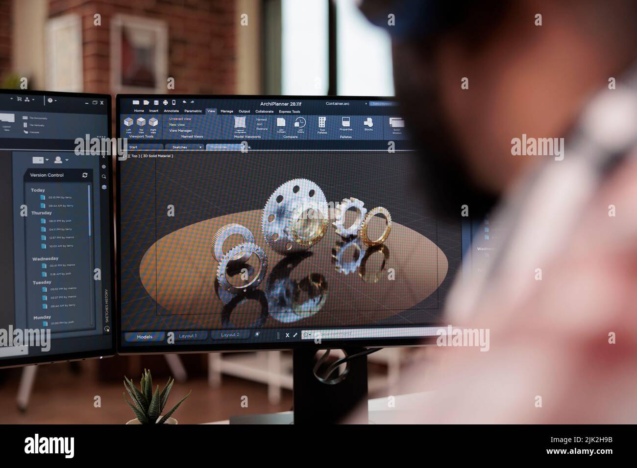 Développeur de machines de prototypage sur ordinateur, port d'écouteurs et création de modèles d'engrenages industriels sur des logiciels techniques. Développement de graphiques de moteur de machine et fabrication 3D. Banque D'Images