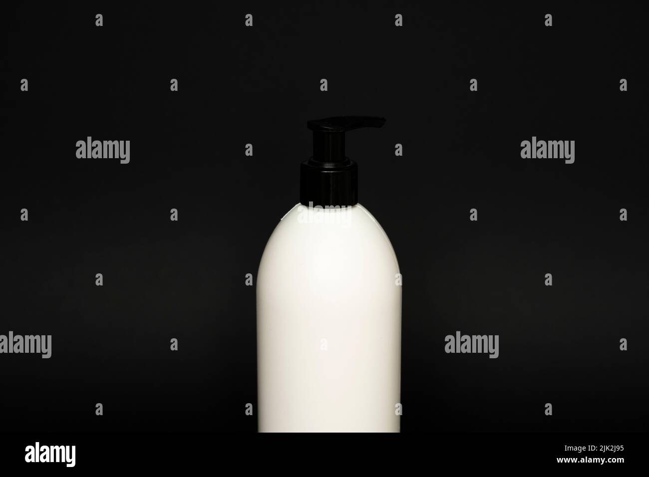 Contenant liquide pour gel, lotion, crème, shampooing, mousse de bain. Flacon en plastique cosmétique avec pompe de distribution sur fond noir. Emballage cosmétique Banque D'Images