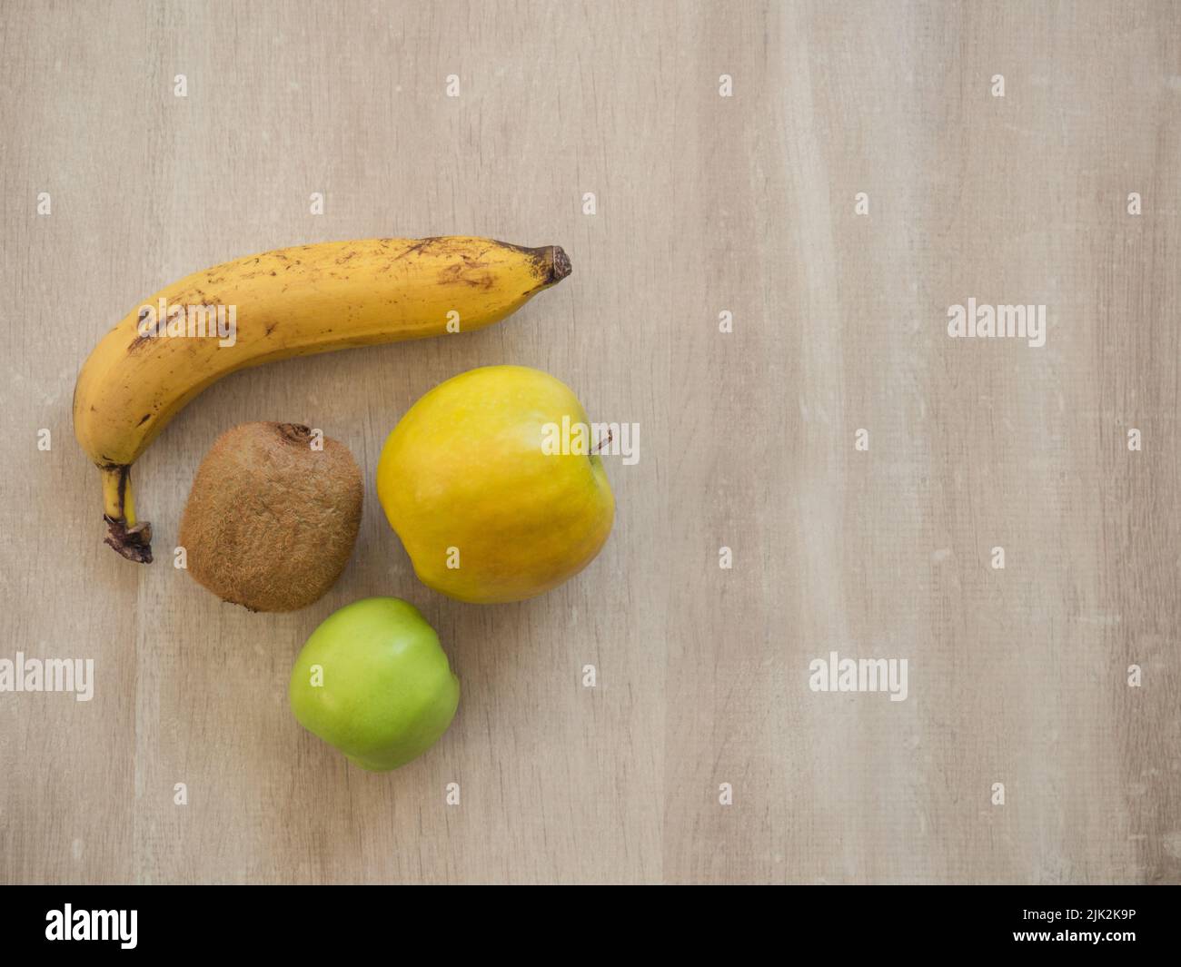 Fruits sains et mûrs sur une table en bois: Banane, pomme, kiwi Banque D'Images