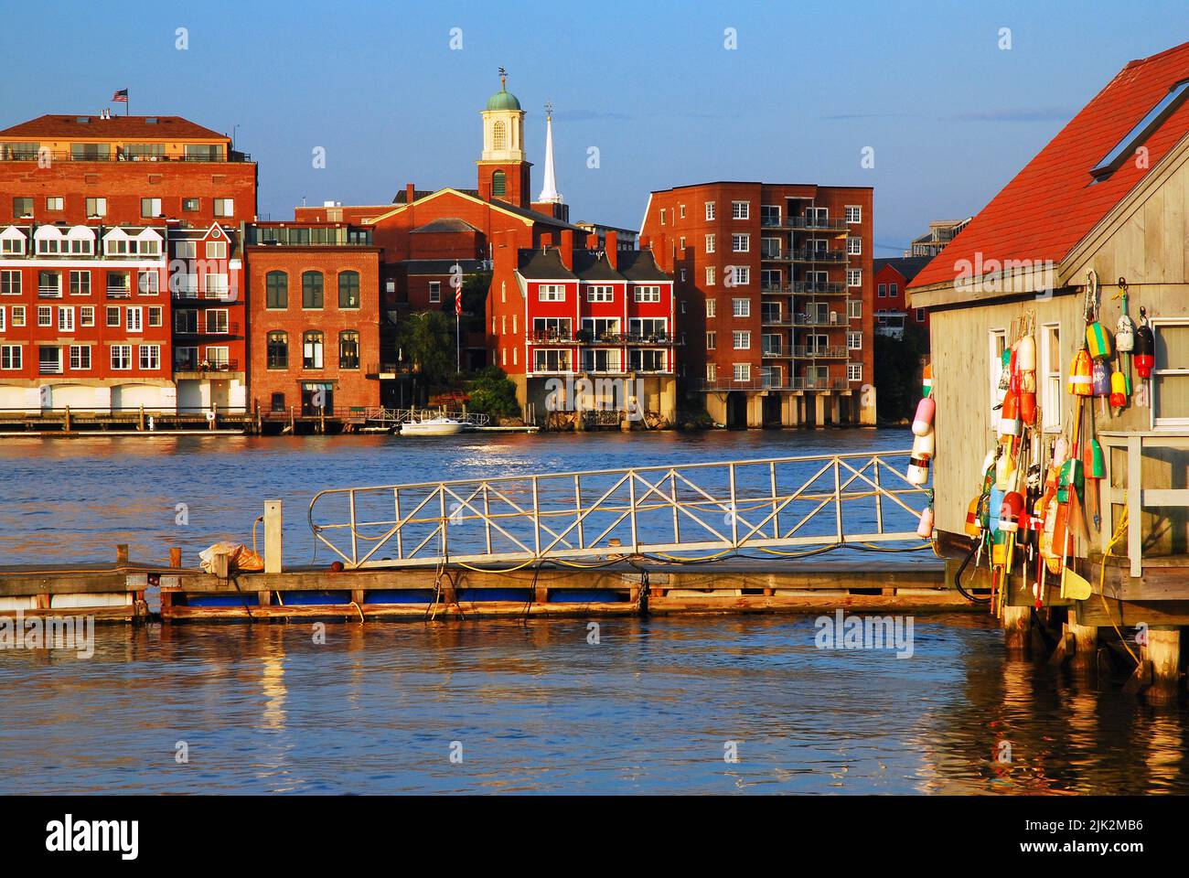 Une cabane de bord de mer rustique avec des bouées de homard colorées contraste avec le nouveau développement de front de mer de Portsmouth, New Hampshire Banque D'Images