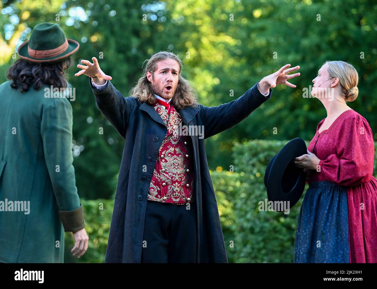 27 juillet 2022, Brandebourg, Rheinsberg: Les chanteurs Gergely Kereszturi (l-r) comme Kruschina, Leo Bachmann comme Kezal et Johanna Risse comme Kathinka se produisent dans une scène de la pièce "la mariée Barbrée" sur scène au Heckentheater. Dans le cadre de l'Opéra de chambre du château de Rheinsberg, la représentation peut être expérimentée à huit représentations sur 30 juillet, 2, 3, 5, 6, 10, 12 et 13. Photo: Jens Kalaene/dpa Banque D'Images