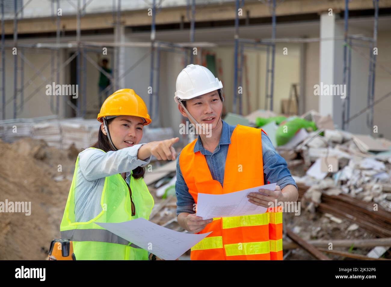 Le gestionnaire de l'ingénieur inspecte les chantiers de construction et vérifie les plans d'aménagement du projet de construction de la maison de ville Banque D'Images
