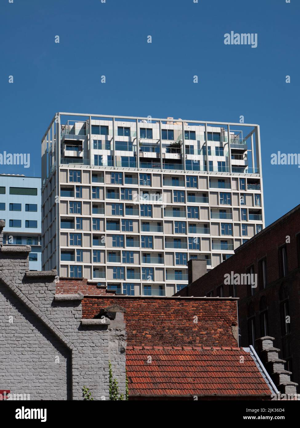Anvers, Belgique, 24 juillet 2022, le bâtiment d'appartements s'élève au-dessus des toits de maisons dans une rue d'Anvers Banque D'Images