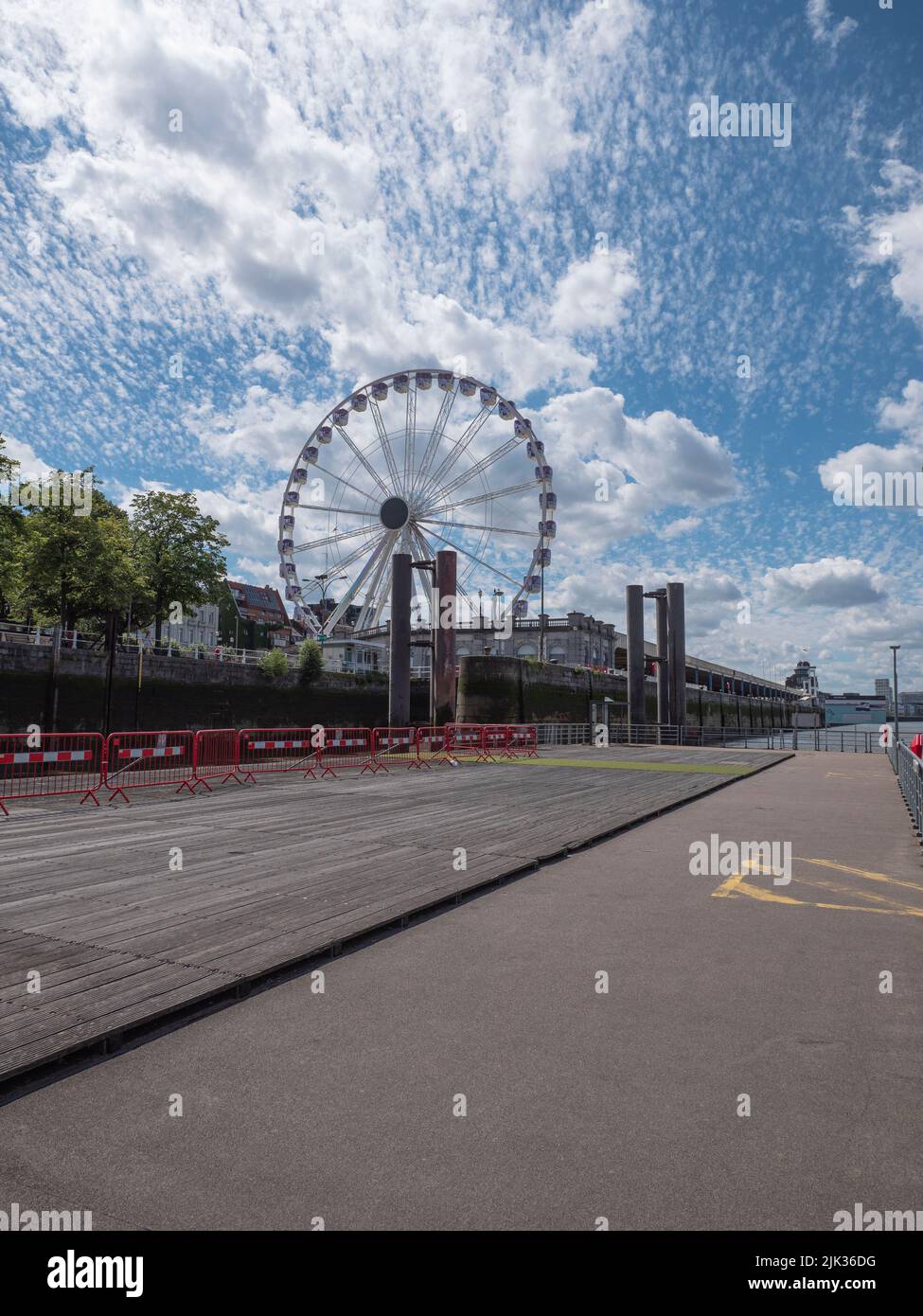 La grande roue d'Anvers avec un beau ciel bleu avec des nuages blancs comme arrière-plan à un lieu d'embarquement vide pour le bateau-bus Banque D'Images