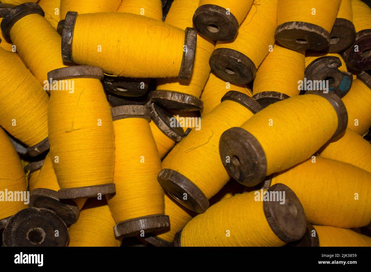 grand fil jaune de grup sur bobine de bois, fil sur tube, une collection de fils jaunes sur bobine, qui sera fabriquée. fil jaune. fil jaune. Banque D'Images