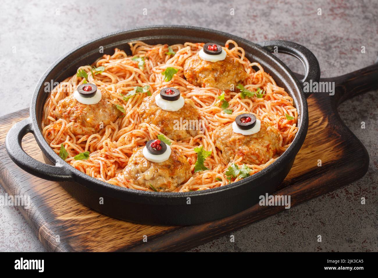 Halloween dîner de boulettes de viande avec des yeux de monstre et des pâtes avec sauce tomate dans une poêle sur la table gros plan. Horizontale Banque D'Images