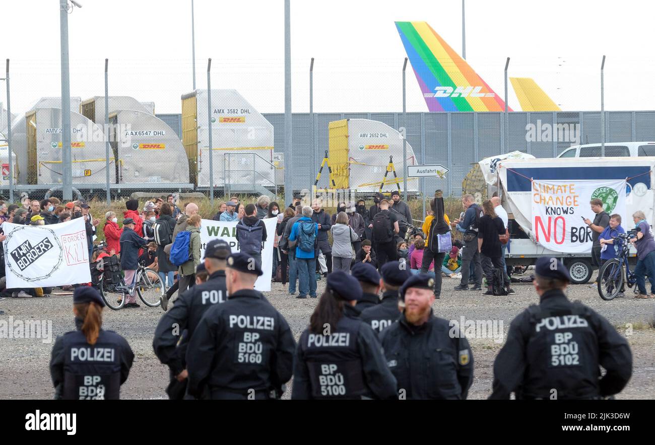 Schkeuditz, Allemagne. 30th juillet 2022. Les participants à un rassemblement se réunissent devant la porte d'accès de la compagnie de fret aérien DHL à l'aéroport de Leipzig-Halle. Environ 250 activistes de l'environnement protestent contre l'expansion prévue du centre de fret. Credit: Sebastian Willnow/dpa/Alay Live News Banque D'Images