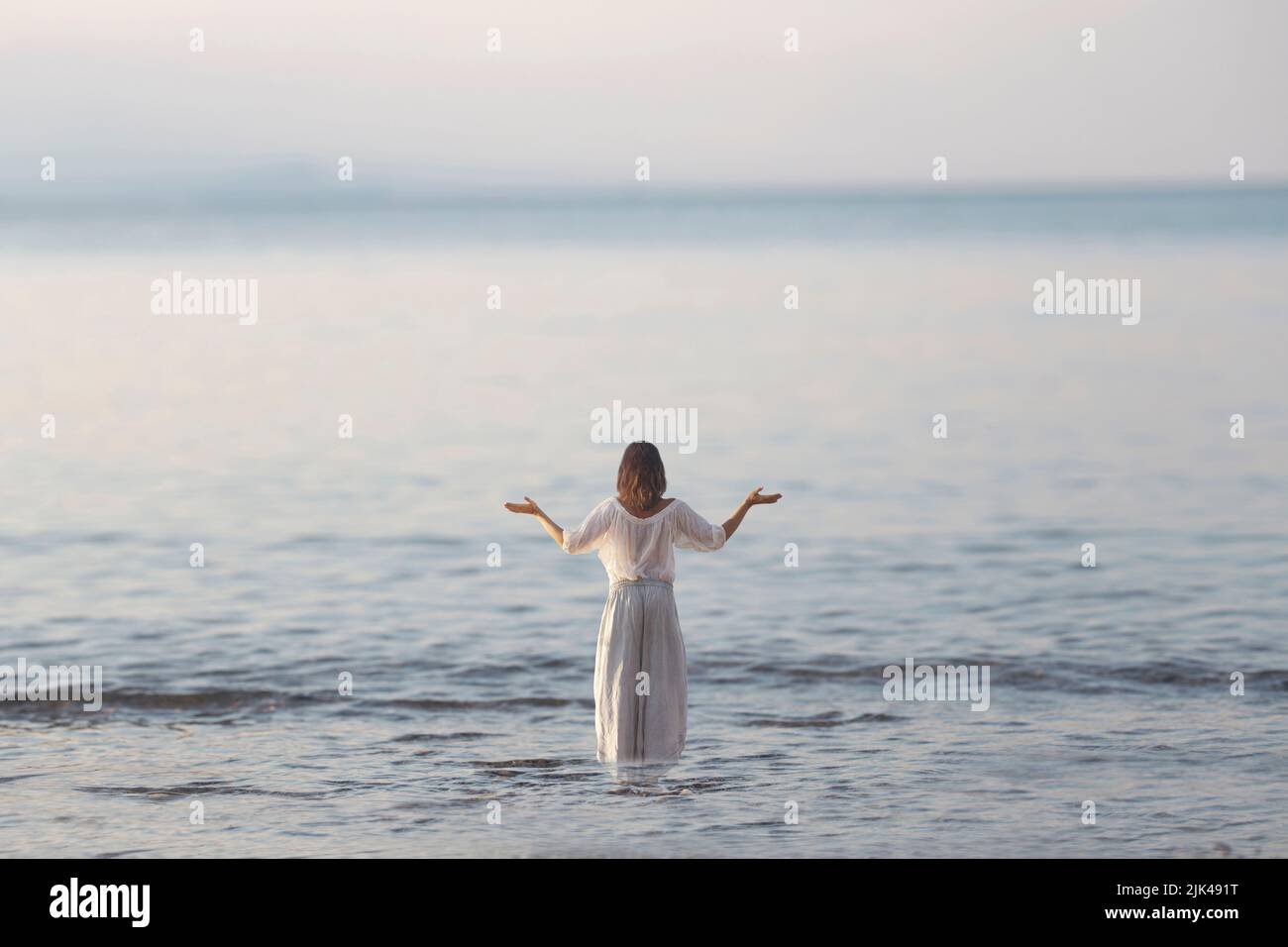 femme fait des exercices de yoga en face de l'océan Banque D'Images