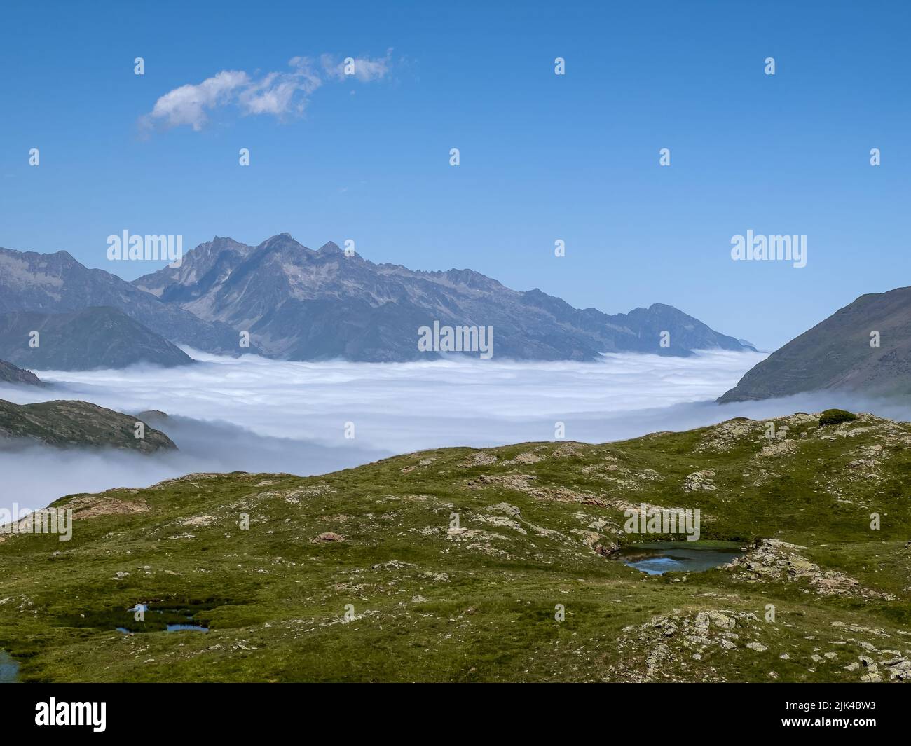 Le Cirque de Troumouse (Pyrénées) avec des nuages qui remplissent la vallée en dessous et ciel bleu clair d'été Banque D'Images