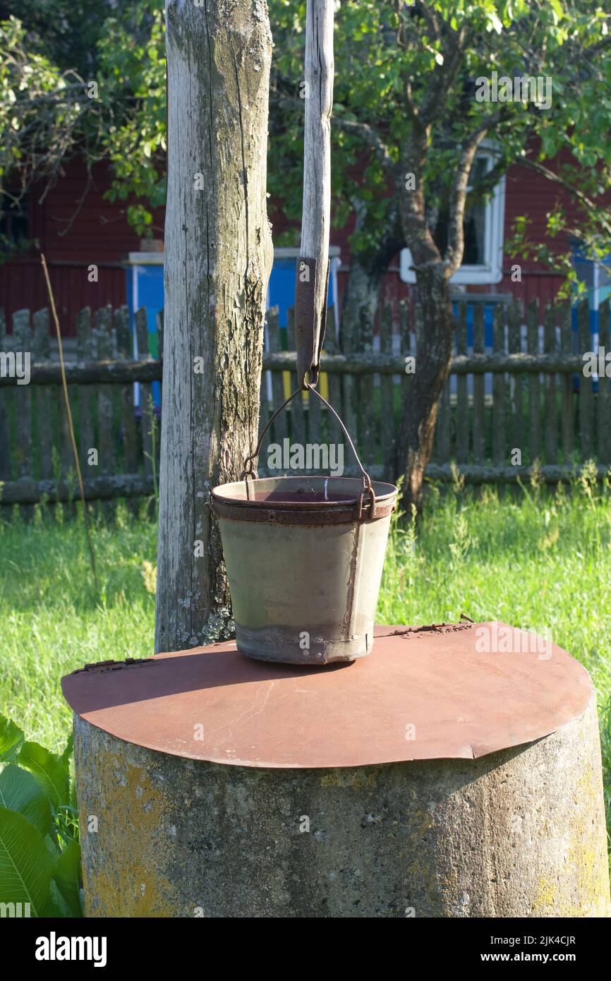 Vieux village bien fait de cercles de béton. Un seau est suspendu au-dessus. Banque D'Images