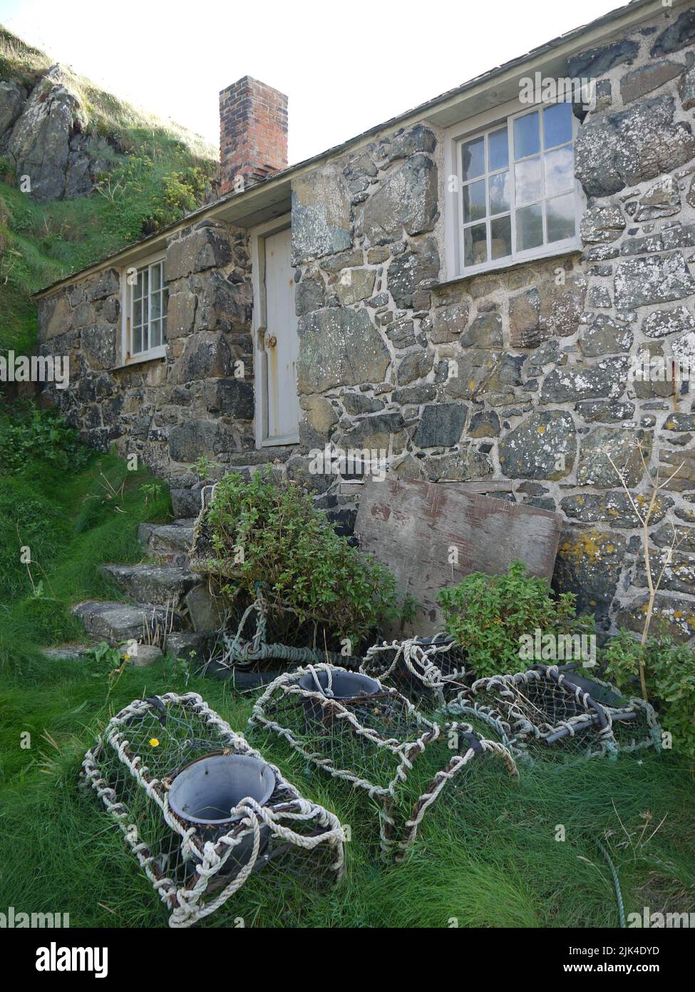 Vue verticale du cottage du port de Net Loft avec Withy pots, Million Cove, Cornwall, Royaume-Uni Banque D'Images