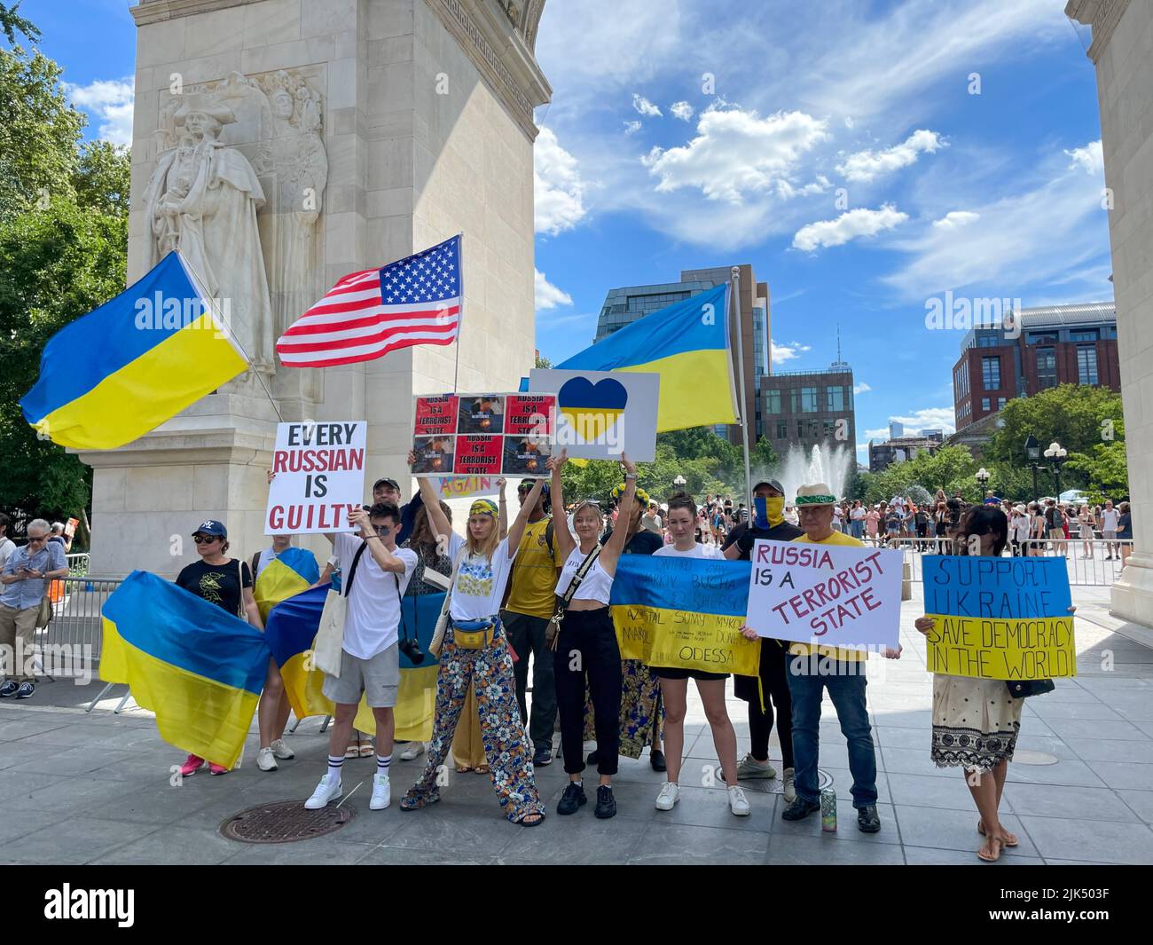 Les participants se sont réunis pour une photo portant le drapeau ukrainien devant Washington Square Park Arch à Manhattan, New York, afin de montrer leur soutien à l'Ukraine Banque D'Images