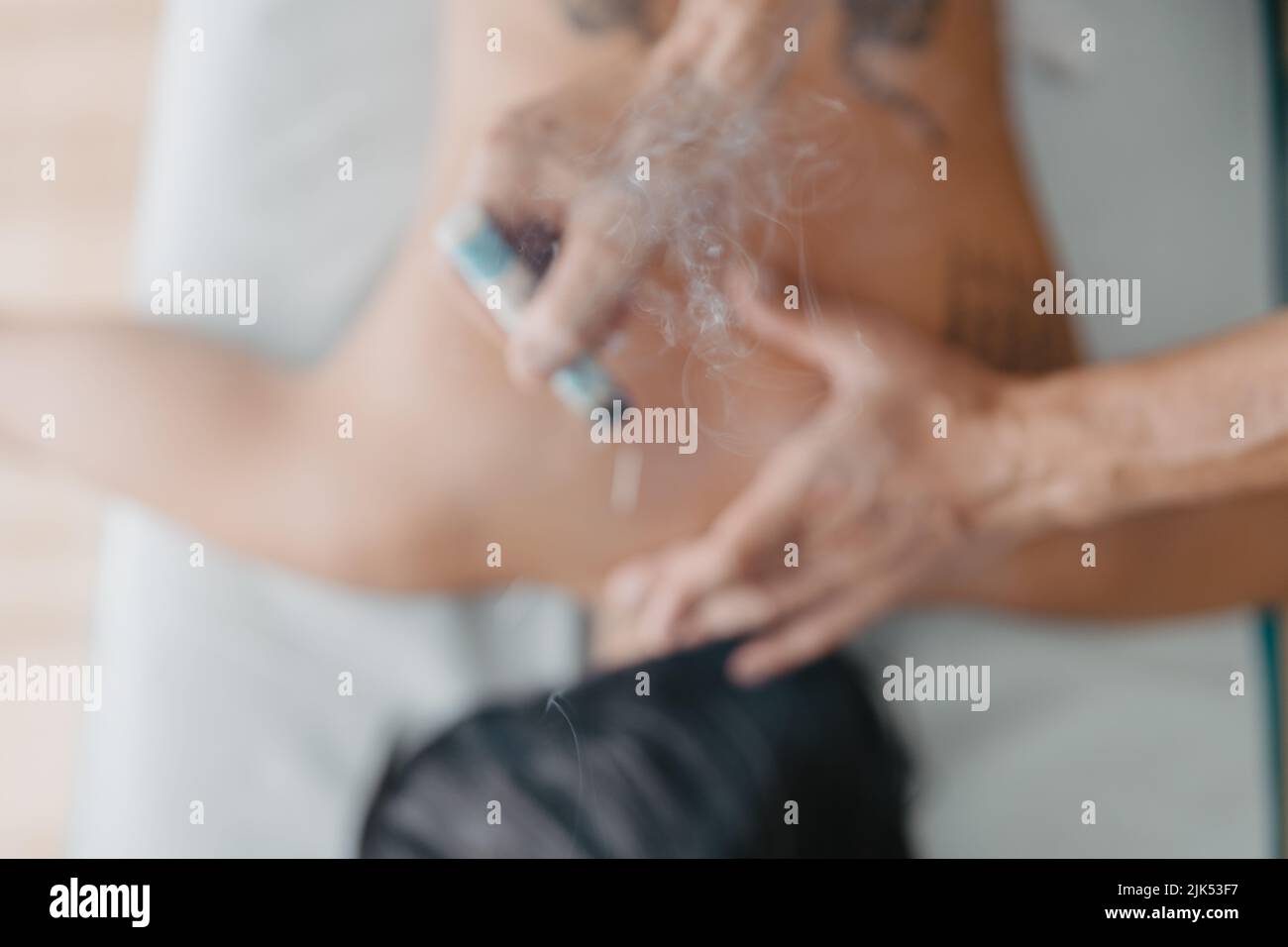 zénith coup de fumée sortant d'un moxa cigare dans une session d'acupuncture Banque D'Images