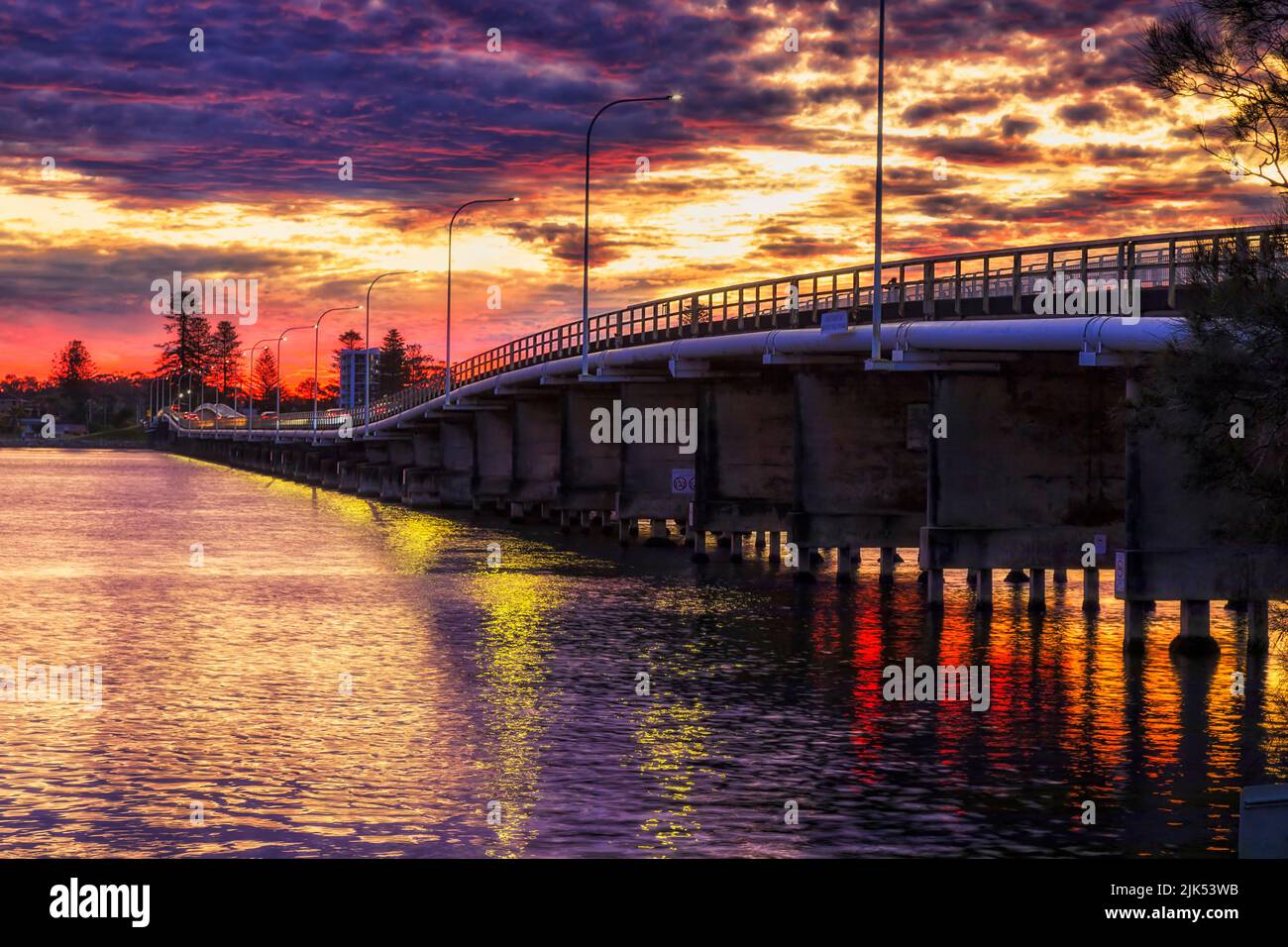 Traversez le pont de la rue en traversant la rivière Coolongolook sur le lac Wallis entre les villes de Forster et Tuncurry au coucher du soleil. Banque D'Images