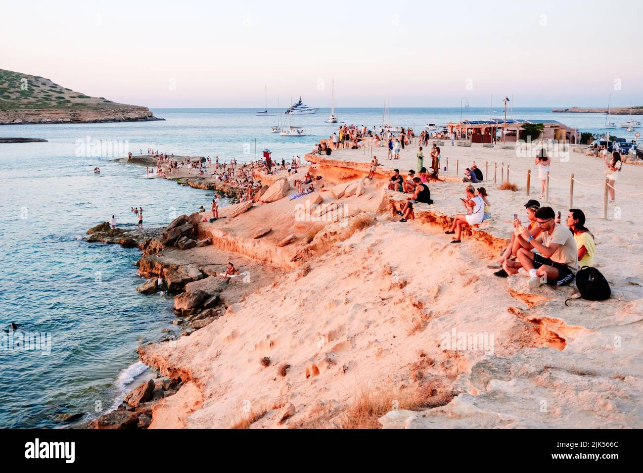 Ibiza, espagne - 28 juillet 2022 : la femme profite du coucher de soleil sur la rive d'une plage paradisiaque pendant ses vacances d'été. Banque D'Images