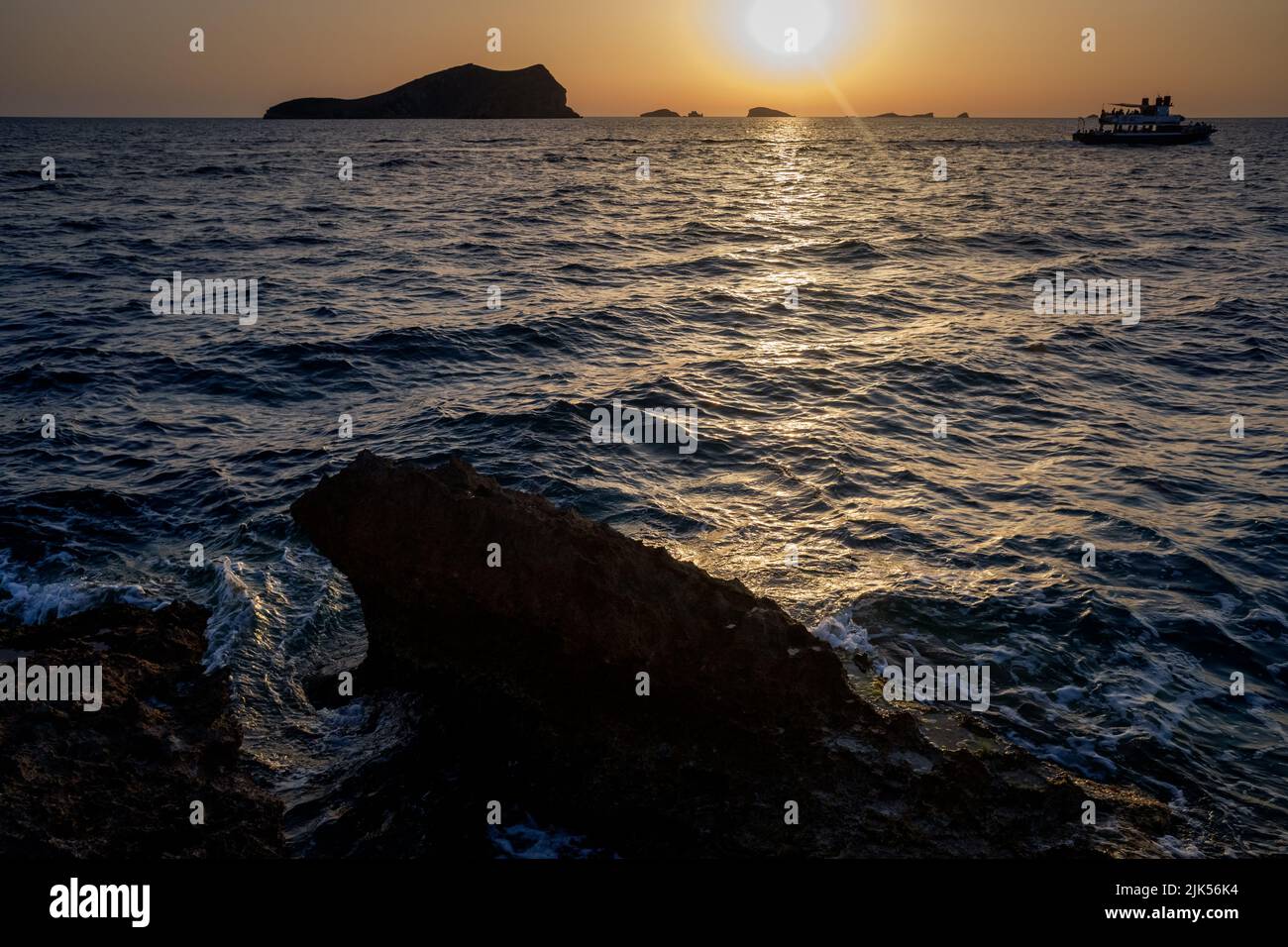 Magnifique et chaleureux coucher de soleil dans la mer Méditerranée de la côte d'Ibiza, soleil se cachant à l'horizon. Banque D'Images
